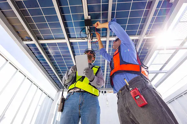 Technicien effectuant un diagnostic sur des panneaux solaires défaillants